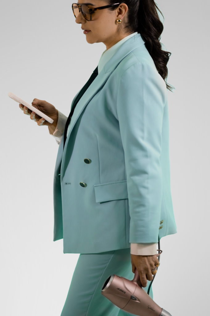 Dra. Wilma Viviane de terno verde-água com celular na mão em foto corporativa